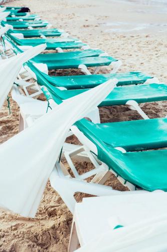 a row of lounge chairs on the beach at Mr. Ben Yehuda - By TLV2GO in Tel Aviv