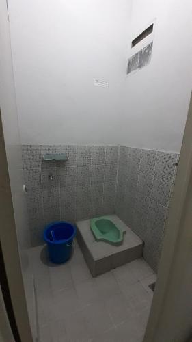 y baño con aseo verde en una cabina. en Rumah Rahman Syari'ah, en Bekasi