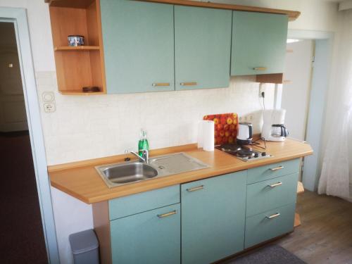 a kitchen with blue cabinets and a sink at Ferienwohnungen und Ferienhaus im Nixenweg in Hohwacht