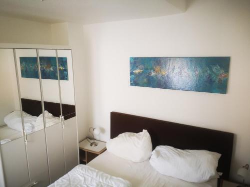 a bedroom with a bed with white sheets and pillows at Ferienwohnungen und Ferienhaus im Nixenweg in Hohwacht