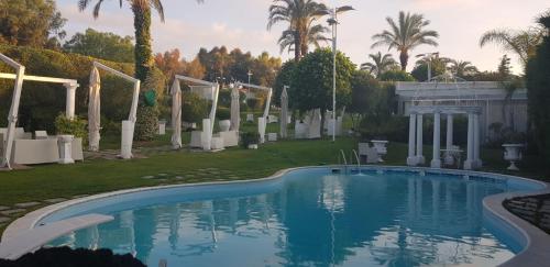 - une piscine dans une cour avec des palmiers dans l'établissement B&B Laura, à Terzigno