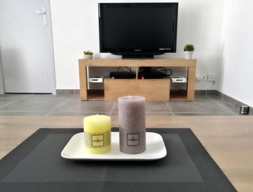une bougie sur une assiette sur une table avec une télévision dans l'établissement T4 - Université Plages Sud, à Perpignan