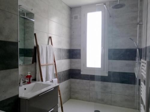 une salle de bain avec un lavabo et une douche avec une fenêtre dans l'établissement T4 - Université Plages Sud, à Perpignan