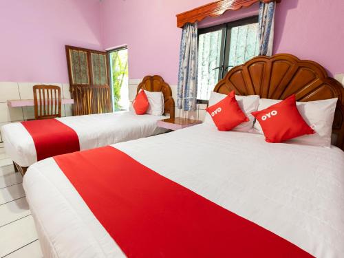 2 camas en una habitación con rojo y blanco en Hotel Posada Agua Escondida, en Cihuatlán