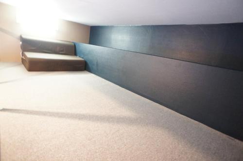 a room with a couch and a wall at Plusone Nishikoen in Fukuoka
