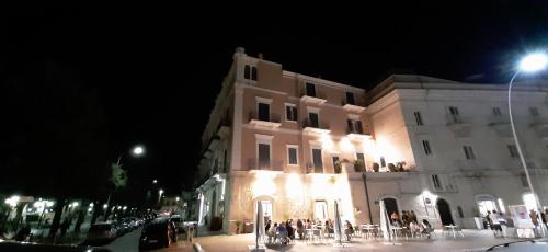 a large building with people standing outside at night at Palace B&B in Acquaviva delle Fonti
