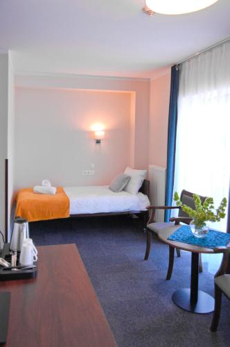 a hotel room with a bed and a table at Hotel Przy Solankach in Grudziądz
