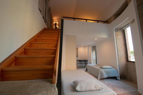 a room with a staircase with a bed and a stair case at Quinta da Malaposta - Boutique Hotel & Eventos in Vila Nova de Cerveira