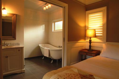 a bathroom with a bed and a tub and a sink at Marysville Garden Cottages in Marysville