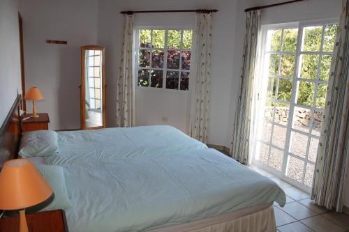 um quarto com uma cama grande e 2 janelas grandes em Villa Los Lomos em El Paso