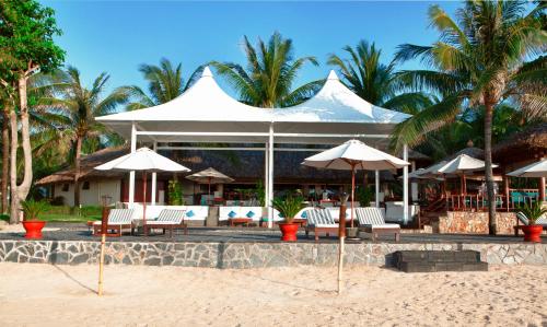 a resort with chairs and umbrellas on the beach at Blue Ocean Resort in Mui Ne