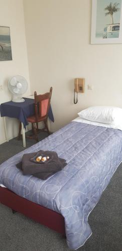 uma cama com um edredão azul, uma mesa e uma cadeira em HCR de Zwaan em Kapelle