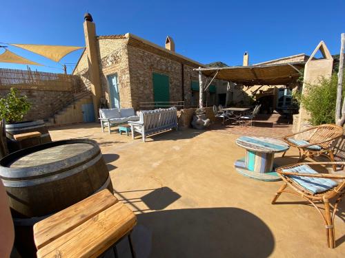 a patio with chairs and tables and a barrel at Can Massana in Pau