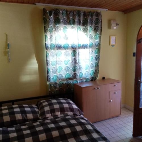 a bedroom with a bed and a window at Tulman Apartment in Balatonberény