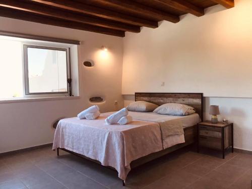 1 dormitorio con 1 cama con 2 almohadas en Sarris Ligaridia Apartments, en Naxos Chora
