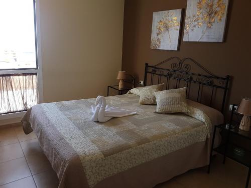 una camera da letto con un letto e un asciugamano bianco di Residencial Cary II - Apartamento Familiar a Poris de Abona