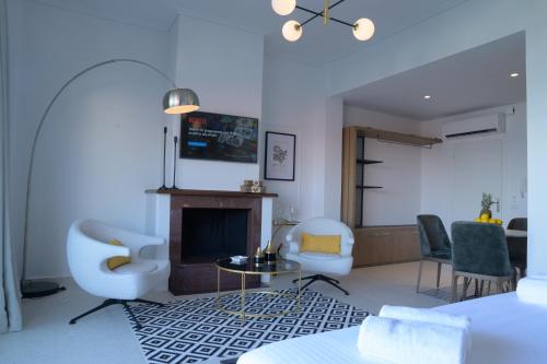 a living room with a fireplace and two chairs at The Well View in Preveza