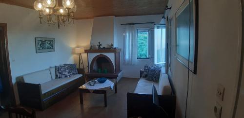 a living room with a couch and a fireplace at House in Zaloggo in Preveza