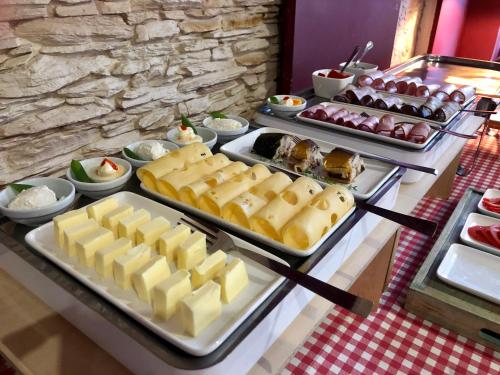 a buffet with cheese and other foods on a table at Hotel Azyl in Gorzów Wielkopolski
