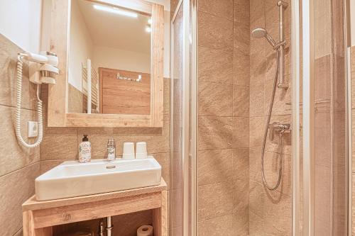 a bathroom with a sink and a shower at Nockberge Lodge in Bad Kleinkirchheim