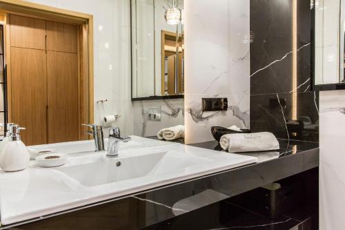 a bathroom with a white sink and a mirror at Tatra Resort & SPA in Kościelisko