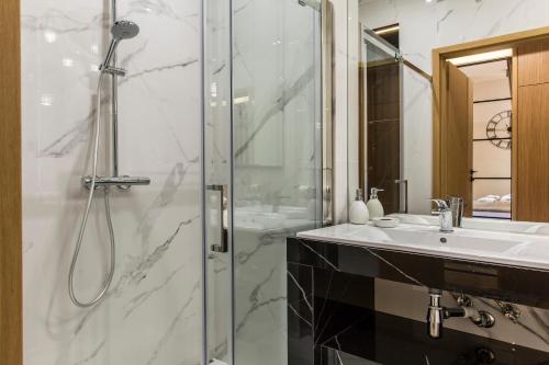 a bathroom with a shower and a sink at Tatra Resort & SPA in Kościelisko