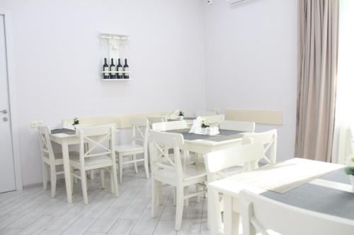 a white dining room with white tables and chairs at Hotel Casa calda in Kutaisi