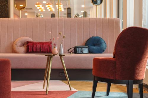 a living room with two chairs and a couch at Holiday Inn - the niu, Loco Munich North by IHG in Munich