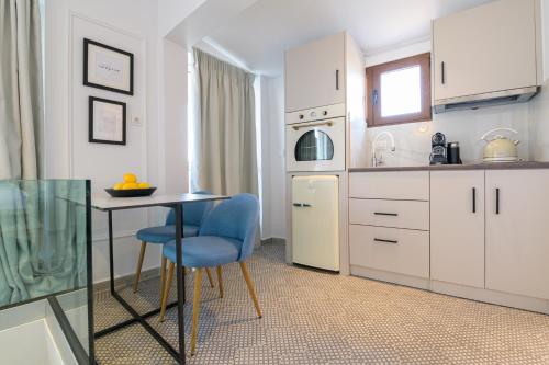 a kitchen with a table and a blue chair at The Well View in Preveza