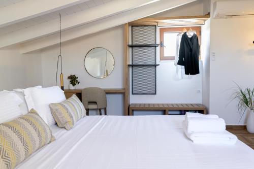 a bedroom with a white bed and a mirror at The Well View in Preveza