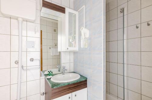 a white bathroom with a sink and a mirror at Villa Paradiso 2 in Dubrovnik