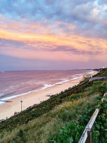 a view of a beach and the ocean at sunset at Alexander Lodge in Bournemouth