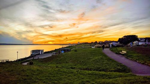 a sunset over a body of water with a path at Alexander Lodge in Bournemouth