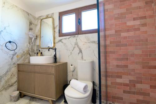a bathroom with a toilet and a sink and a mirror at The Well View in Preveza