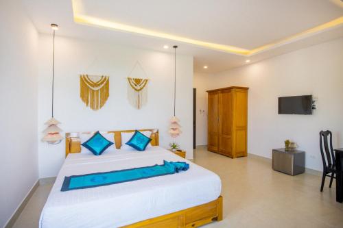 a bedroom with a bed and a tv on the wall at Hoi An Village Villa in Hoi An