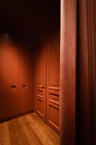 an empty room with red walls and wooden floors at The Bold Type Hotel, a Member of Design Hotels in Patra