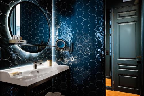 a bathroom with a sink and a mirror at The Bold Type Hotel, a Member of Design Hotels in Patra