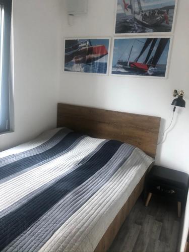 a bed in a bedroom with pictures on the wall at Széplak No.1. in Siófok