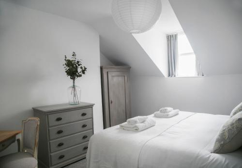 哈羅蓋特的住宿－Oswald House deluxe 3 bedroom apartment，一间卧室配有床和一个带毛巾的梳妆台。