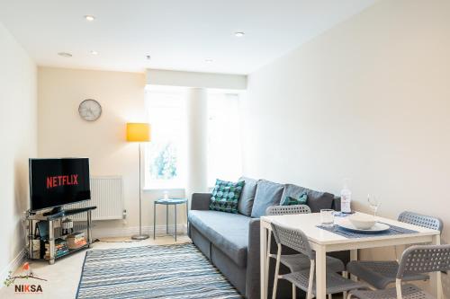 a living room with a couch and a table at Niksa Serviced Accommodation Welwyn Garden City- One Bedroom in Welwyn Garden City