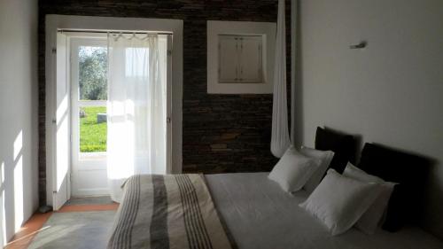 a bedroom with a bed with a brick wall at Monte Falperras in Mourão