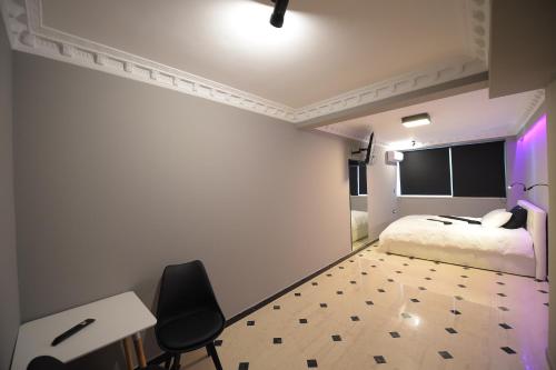 a bedroom with a bed and a desk and a chair at Pietra Mare Suites in Patra