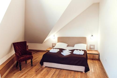 a bedroom with a bed and a chair at Verhovel Hotel in Verkhovyna