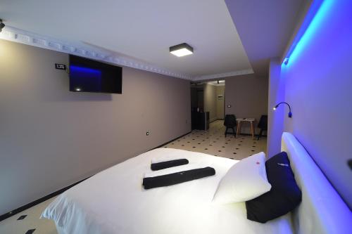 1 dormitorio con 1 cama blanca grande con almohadas negras en Pietra Mare Suites en Patras