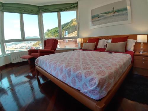 a bedroom with a bed and a chair and windows at Laredo Ocean Port in Laredo