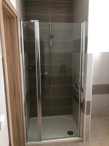 a shower with a glass door in a bathroom at Apartmány U Stadionu in Šumperk