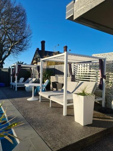 a group of white benches sitting on a patio at Town House Motor Inn in Horsham
