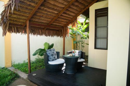 a patio with two chairs and a pergola at Hotel Amazon Bed And Breakfast in Leticia