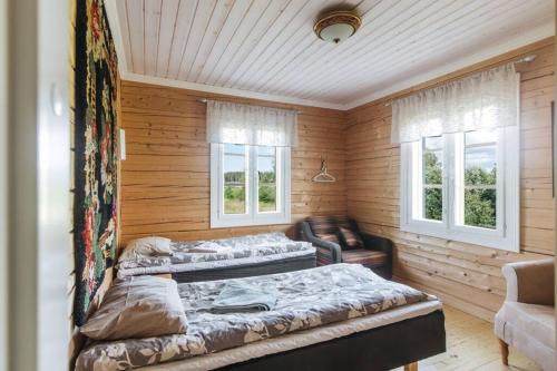 una camera con due letti e un divano e due finestre di Akselin Lomatupa a Kauhajoki