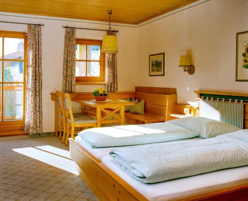 two beds in a bedroom with a table and a dining room at Hochberghaus Resort in Grünau im Almtal